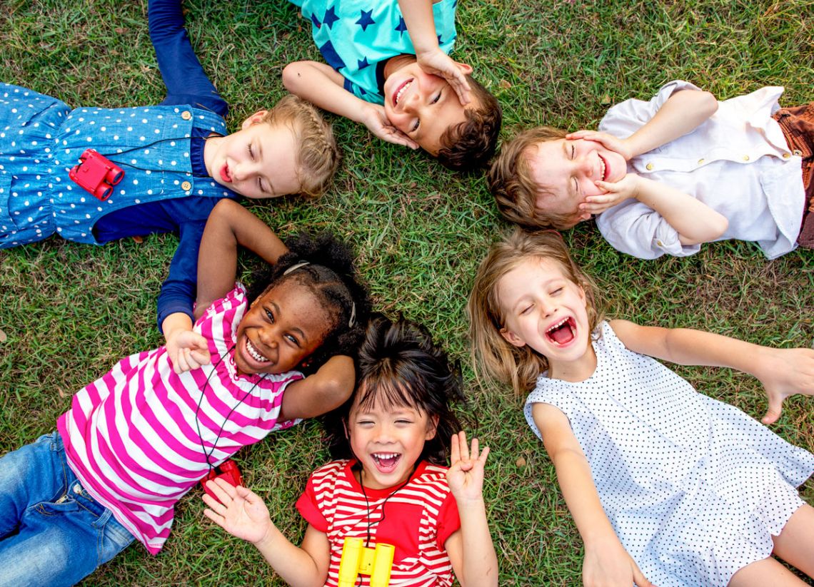 group of kindergarten kids lying on the grass