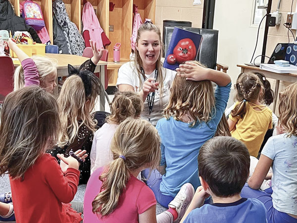 Children in a classroom talking to a teacher