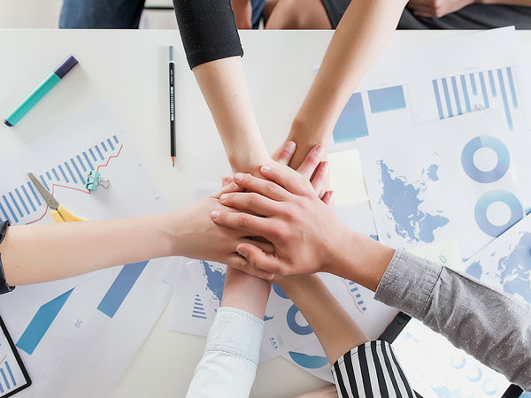 hands on top of each other over a work table