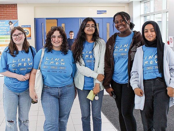 Students standing in the hallway smiling