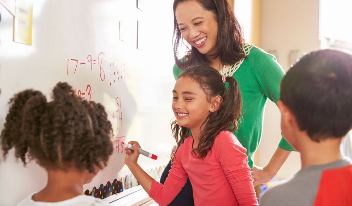 Children doing math on a whiteboard