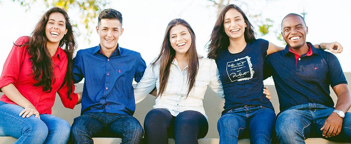 Students sitting down and smiling