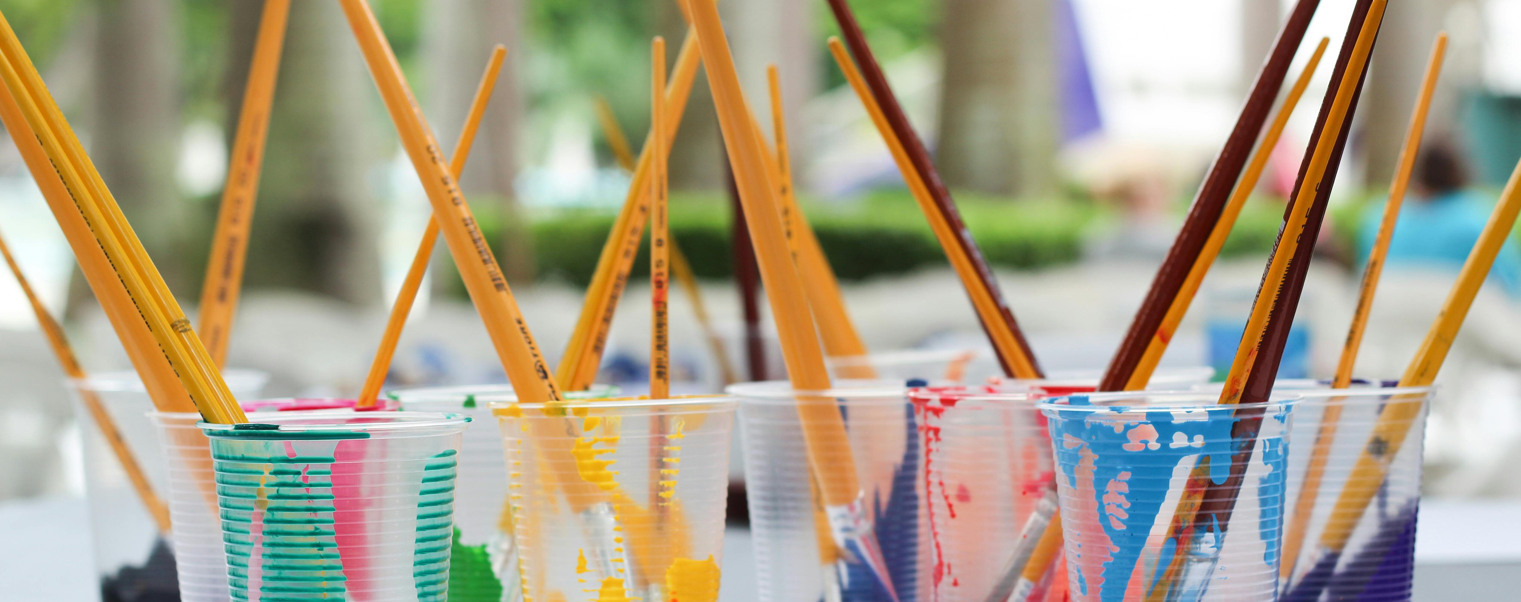 painting brushes in plastic cups