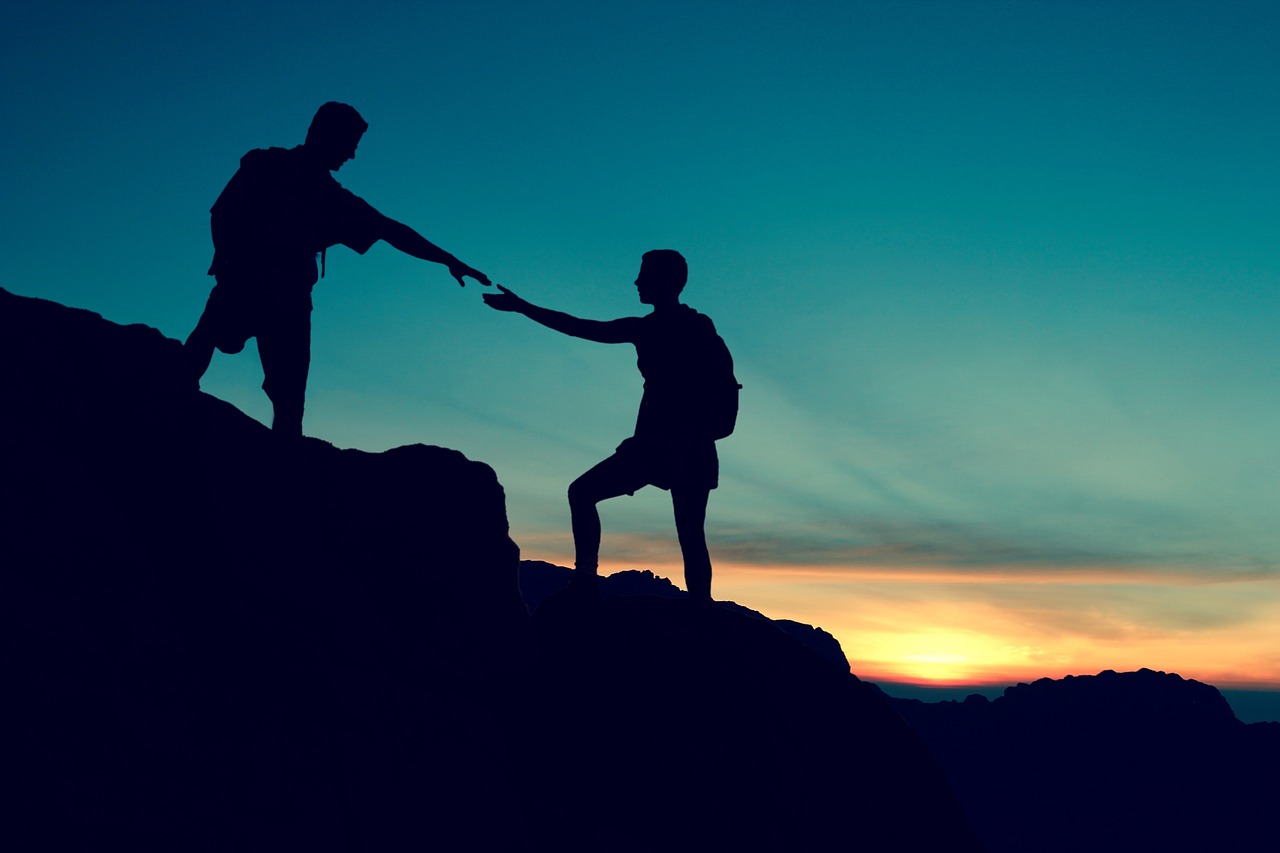 a couple helping each other climbing