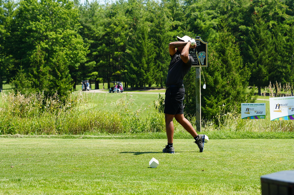 Person swinging club on golf course
