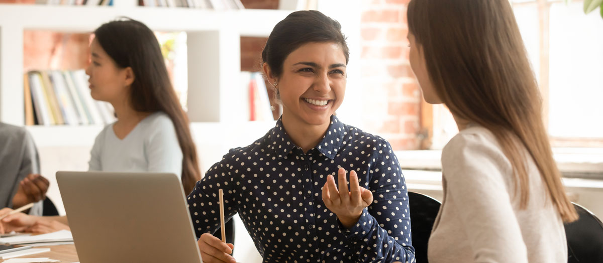 two girls talking in a desk