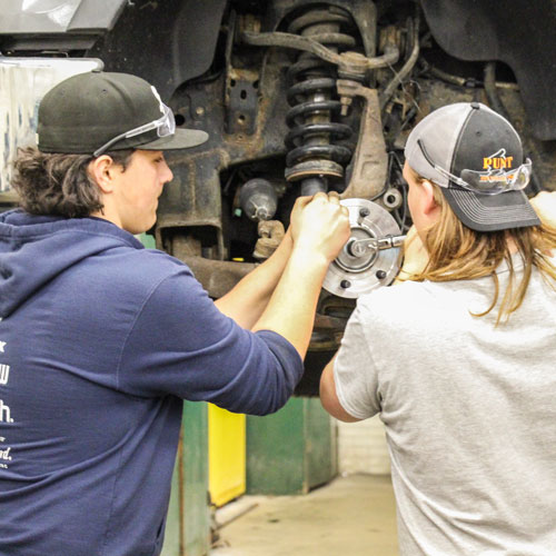 two guys fixing a car